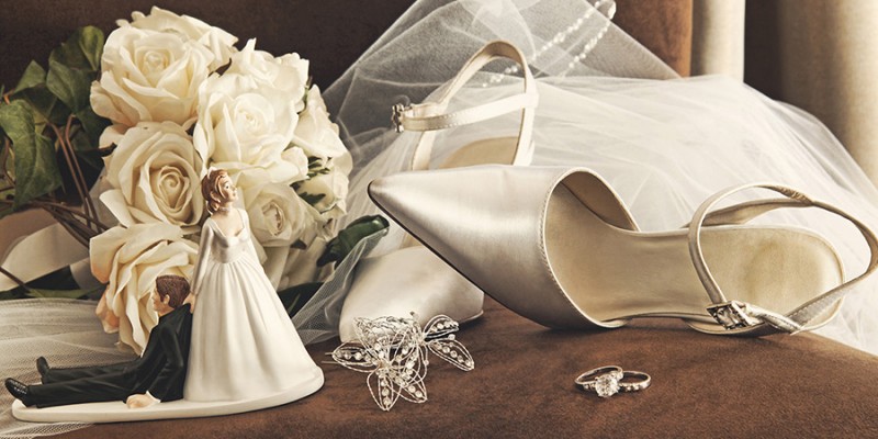 Bouquet of white roses and wedding shoes on chair